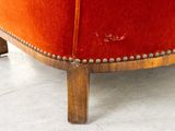 an image of a red couch with studded wood legs in a living room