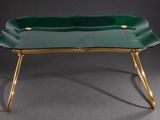 une photo représentant un plateau vert aux pieds dorés posé sur une table