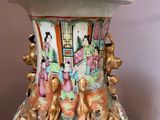 a vase with a painting on it sitting on a table