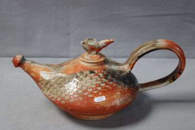 a brown and orange teapot with a bird on it