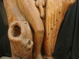 a wooden statue of a man with a bird on his back