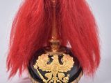 a red wig sitting on top of a black and gold vase