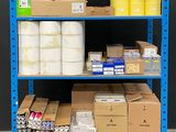 une étagère bleue sur laquelle se trouvent plusieurs boîtes et rouleaux de papier toilette