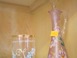 deux vases et un verre posés sur une étagère en verre