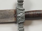 a close up of a sword with a wooden handle