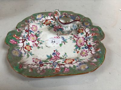 une assiette munie d'une anse et décorée de fleurs