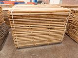 several stacks of wooden planks stacked on top of each other in a warehouse
