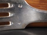 a metal fork with holes on it sitting on a table