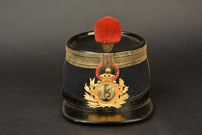 un chapeau noir orné d'un pompon rouge