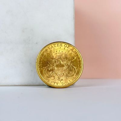 a close up of a gold coin sitting on top of a marble block