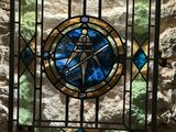 a picture of a stained glass window in a stone wall