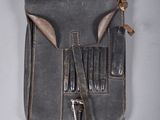 un petit sac gris contenant une paire de ciseaux