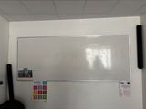 a whiteboard on the wall in the corner of a room