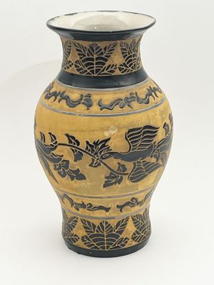un vase orné d'un motif de dragon sur fond blanc