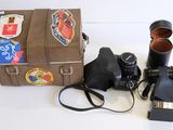 un appareil photo et une valise décorée d'autocollants