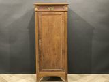 une vieille armoire en bois avec une porte, posée sur un parquet