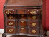 un bureau en bois avec des tiroirs et un miroir accroché au mur