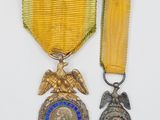 un gros plan sur deux médailles et une médaille posées sur une surface blanche