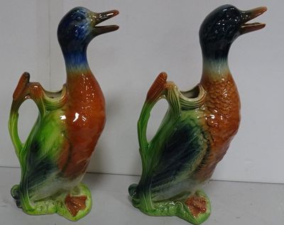 two ceramic ducks that are sitting on a table