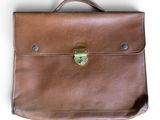 porte-documents en cuir marron sur fond blanc, avec une découpe au niveau de la poignée