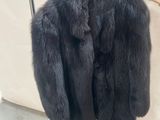un manteau de fourrure noir suspendu à un porte-manteau dans une pièce