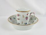 a cup and saucer on a saucer on a white table