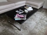 a black coffee table with magazines on it in a living room