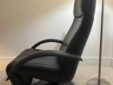 a black recliner chair with a red flower on it