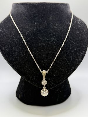 un collier en or blanc orné de trois diamants, porté par un mannequin noir