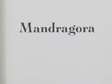 an open book with a black and white image of a mandagora