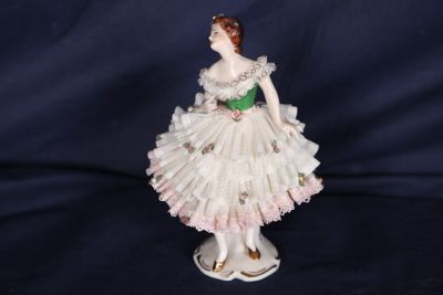 figurine en porcelaine représentant une femme vêtue d'une robe blanche et d'une ceinture verte