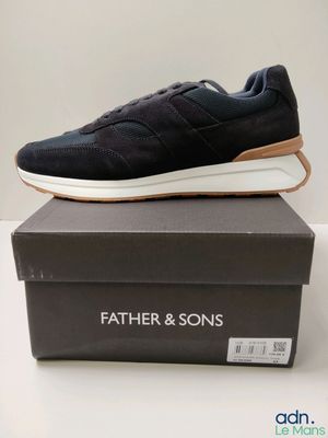 une chaussure noire et blanche posée sur une boîte noire