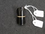 a black cup with a gold band and a price tag on it