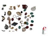 a pile of assorted jewelry on a white surface