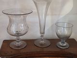 trois vases en verre posés sur une table en bois