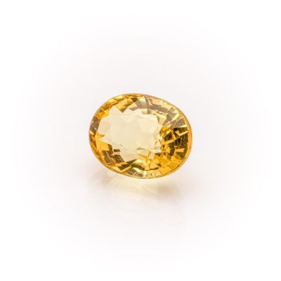 a yellow sapphire stone on a white background
