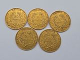 four gold sovereigns, one of which has a crown on it