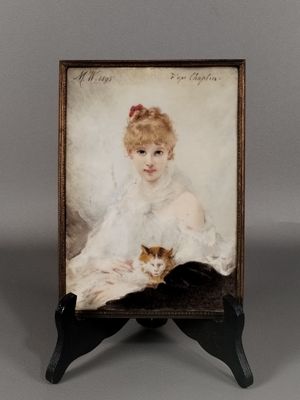 une vieille photo représentant une femme avec un chat posé sur une table