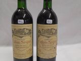 two bottles of red wine sitting next to each other on a table
