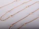 three gold chain necklaces with pearls on a white background