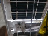 a air conditioner sitting on the floor next to a hose