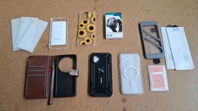 Plusieurs téléphones portables sont posés sur une table, à côté d'autres objets