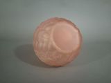 a pink glass vase sitting on a gray surface