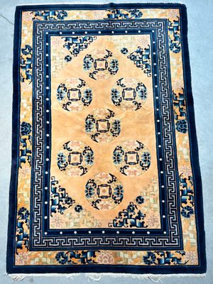 an oriental rug on the ground with a blue border and a yellow background
