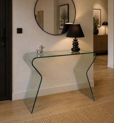 une table en verre sur laquelle se trouvent une lampe et un miroir