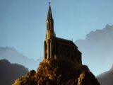 a large building on a mountain with a steeple in the background