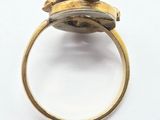 a close up of a gold ring on a white surface