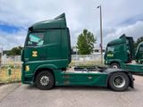two green trucks parked next to each other in a parking lot