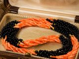 an orange and black beaded necklace in a case