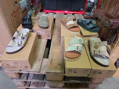 de nombreuses paires de chaussures posées sur une palette dans un entrepôt